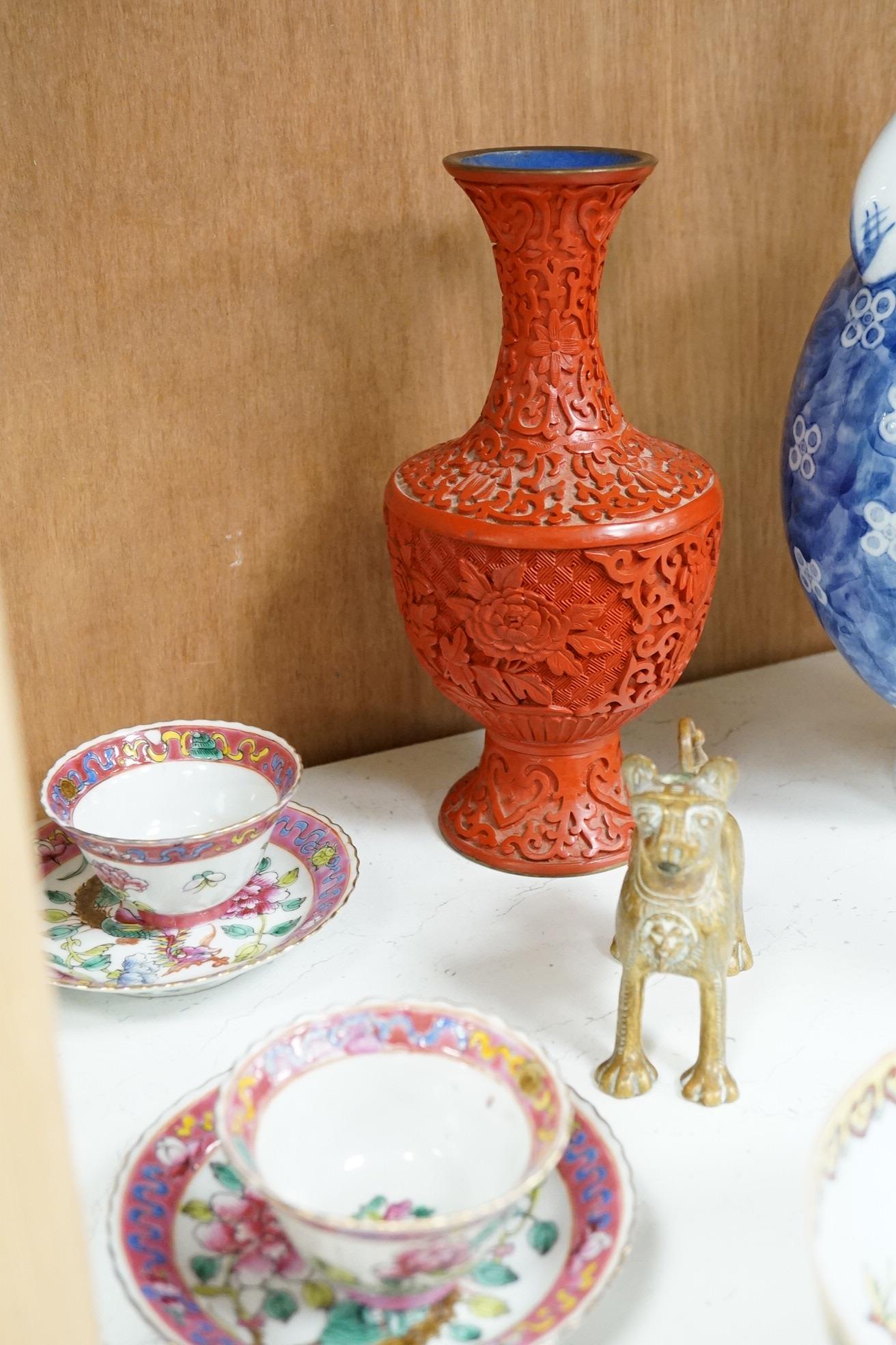 A group of mixed oriental porcelain and metalware to include a Japanese satsuma vase, cinnabar lacquer vase and blue and white teapot, largest 32cm high.